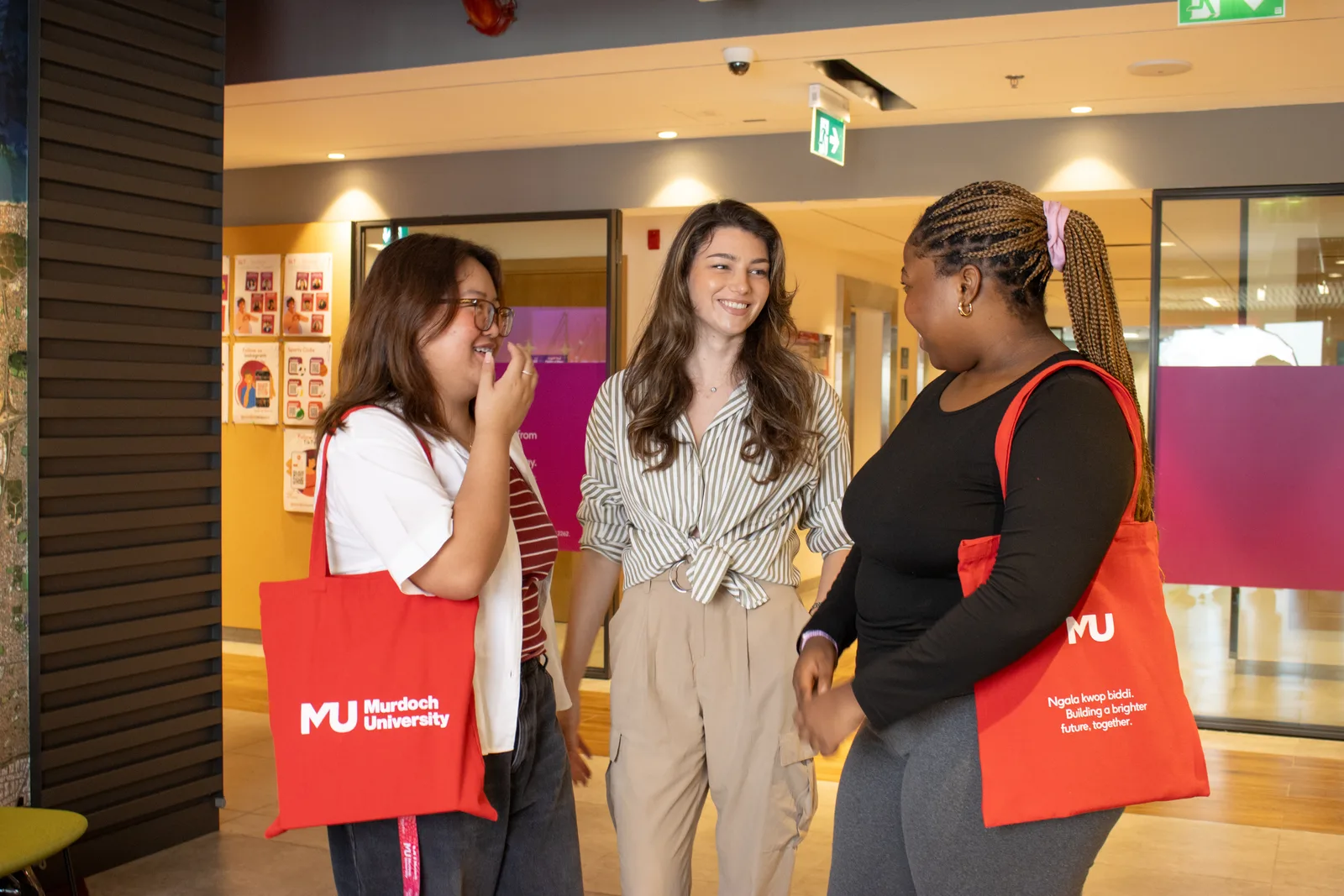 Three members of the Murdoch University Dubai community talking together on campus