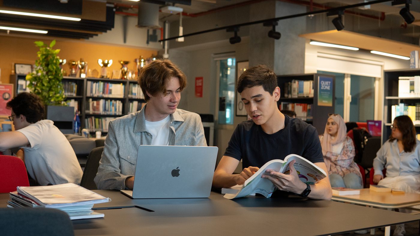 Two Murdoch University Dubai students studying together with a laptop