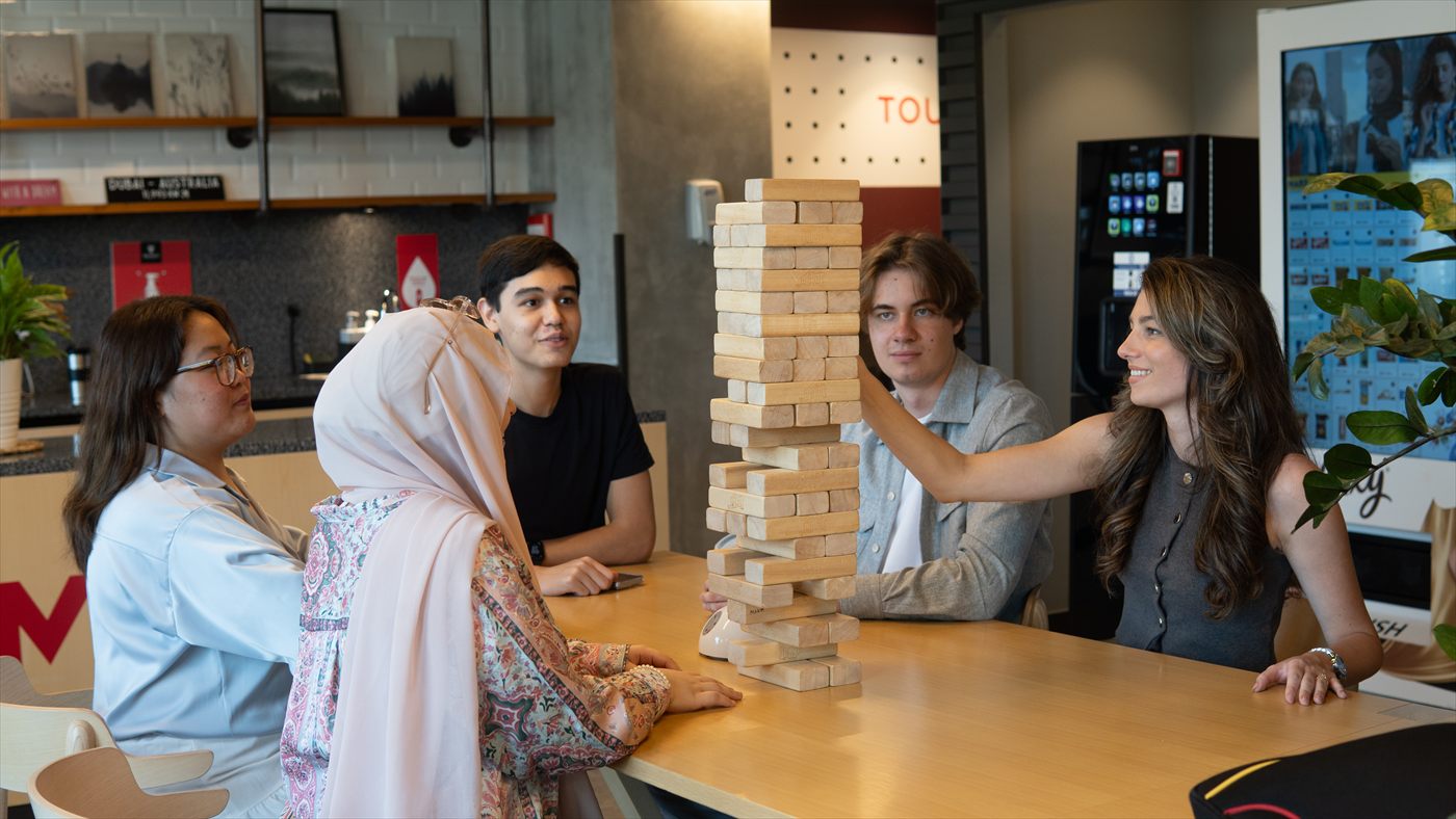 Murdoch University Dubai students playing a wooden block game on campus